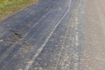 Details of a road polluted with sand and debris from fields