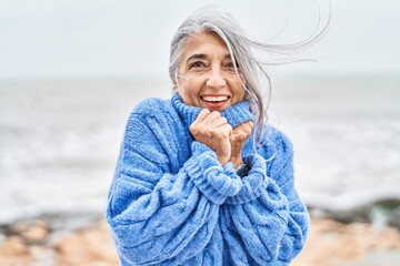 Middle age grey-haired woman smiling confident standing at seaside © Krakenimages.com