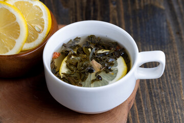 Green tea in a white cup during its brewing