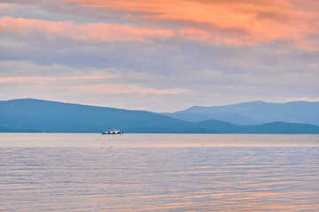 Obraz na płótnie Canvas Kurbulik, Republic of Buryatia, Russia - July 11, 2022: A ship with tourists in the Chivyrkuysky Bay of Lake Baikal.