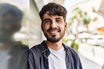 Fototapeta premium Young hispanic man smiling happy standing at the city.