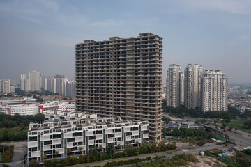 Aerial view of large abandoned concrete shell of residential high-rise real estate and construction...