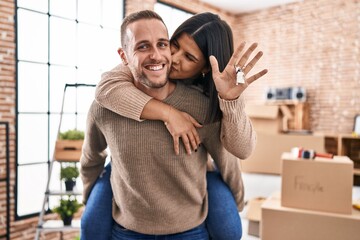Man and woman couple holding girlfriend in back and key at new home