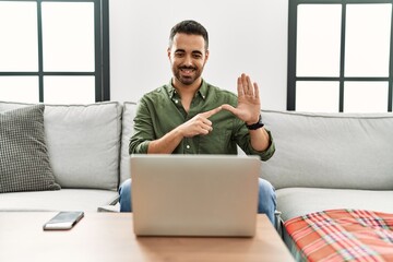 Young hispanic man having video call speaking with deaf language at home
