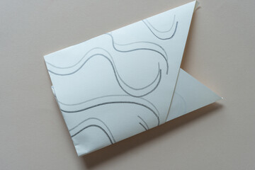 folded paper object with wavy lines