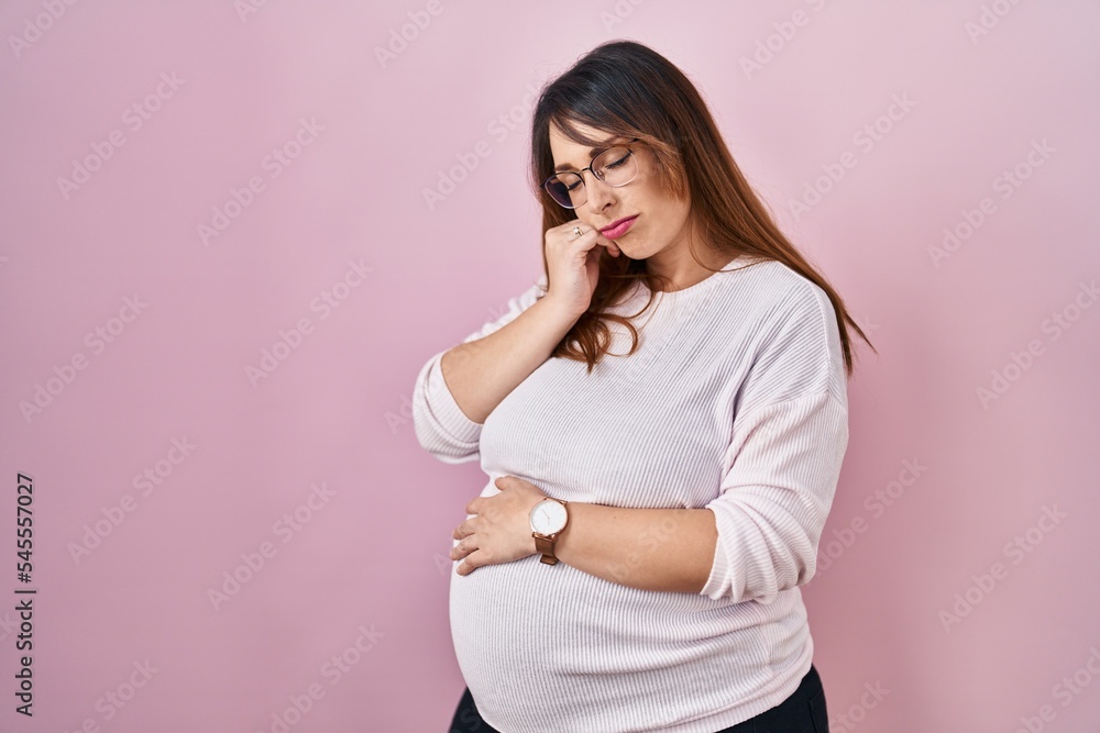 Poster pregnant woman standing over pink background thinking looking tired and bored with depression proble