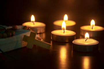 Holy Rosary and Bible on dark candlelight background with customizable space for text or ideas. Copy space and Christianity concept.