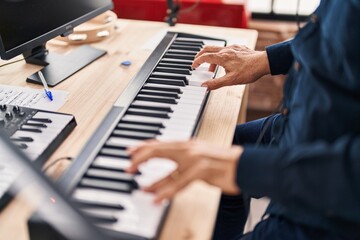 Fototapeta na wymiar Senior man musician playing piano keyboard at music studio