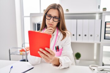 Young woman wearing doctor uniform having teleconsultation at clinic