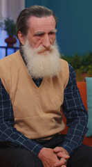 Portrait of sad sick senior old grandfather man at home looks pensive thinks over life concerns or...