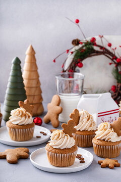 Gingerbread cupcakes with cream cheese frosting topped with gingerbread cookies
