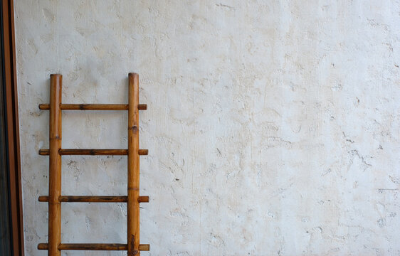 Bamboo Racking And White Concrete Wall With Copy Space.