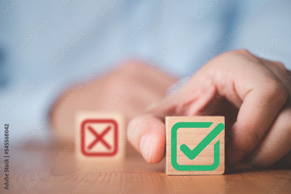 Aufkleber businessman select green correct sign mark between red cross mark which print screen on wooden cube 