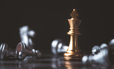 Golden king chess standing among fallen silver chess for winner and defeat after competition ,...