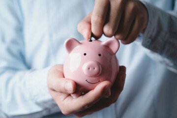 Businessman putting coin to pink piggy bank , Money saving and deposit for investment to get profit...