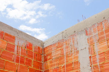 Brick wall under construction of brazilian house, brick under construction in brazil. blocks or bricks (masonry) of red clay on a wall, in the work of Brazilians.