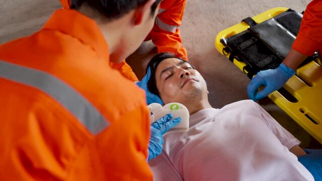 Asian emergency medical technician (EMT) or paramedic team is holding manual stabilization of the head patients and wearing neck collar, Emergency medical services (EMS) nurses concept