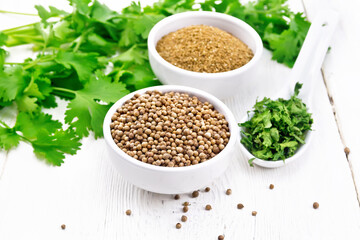 Coriander ground and seeds in bowls on board