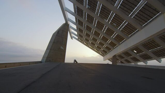 Solar panel structure and modern architecture at sunrise by the sea