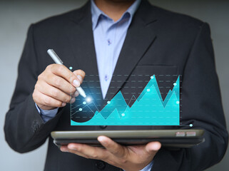 businesspeople using a tablet to view company financial reports, and graphics showing financial and numerical growth data. The concept of financial management is to grow and be profitable.