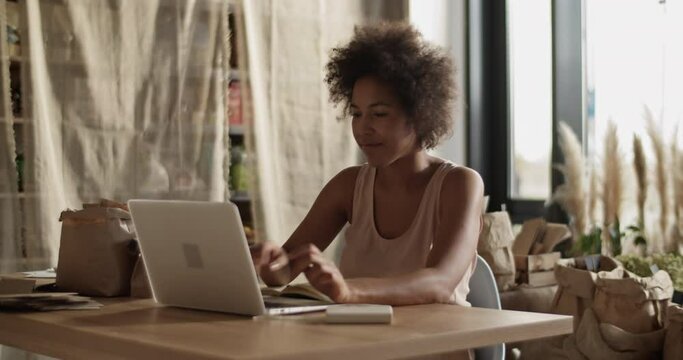 Self employed woman working in own eco shop
