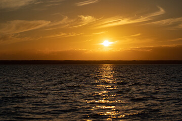 Sun Falling in to the sea. A Spectacular golden Sunset in the ocean with puffy clouds on the sky