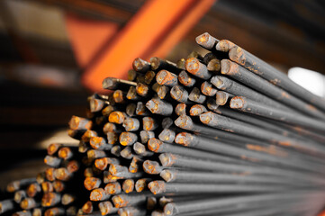 Thin metal rods bunch in cold plant warehouse macro view