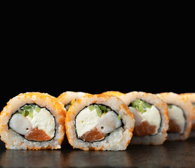 Philadelphia, California sushi. sushi rolls with shrimp and salmon on black background. Shrimp sushi rolls.