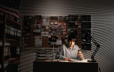 Woman detective working in her office at night
