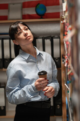Portrait of female detective looking at evidence board in her office
