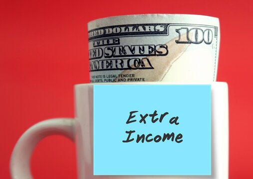 Dollar money cash banknote in white cup on red background with blue stick note written EXTRA INCOME .  concept of make more money, additional income earn from side job or side hustle in gig economy