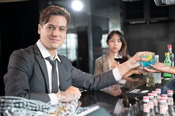 Handsome caucasian businessman drink cocktail at bar in hotel restaurant