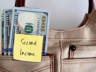 Dollars money in woman bag with sticky note SECOND INCOME ,concept of earn money from side hustle,...