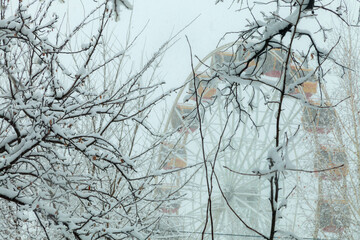 View of the ferris wheel and a tree in the snow