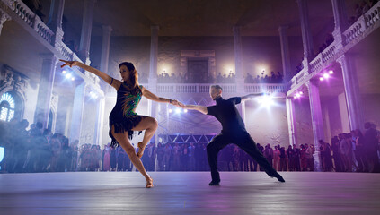 Couple dancers perform latin dance on large professional stage. Ballroom dancing.