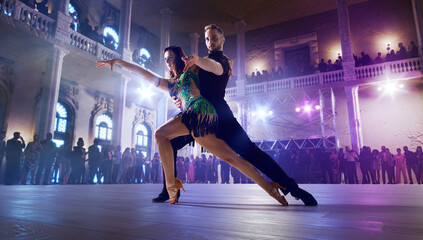 Couple dancers perform latin dance on large professional stage. Ballroom dancing.