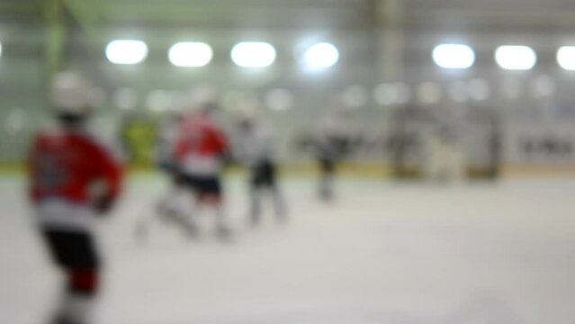 Blurred background. Teams of hockey players playing hockey. Teenage boys play hockey on ice rink at indoor ice stadium. Ice Hockey match championship Sports skating competitions Real professional game