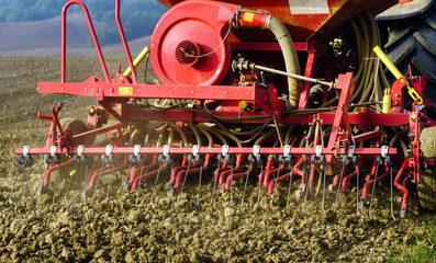 Agriculture tractor sowing seeds and cultivating field.