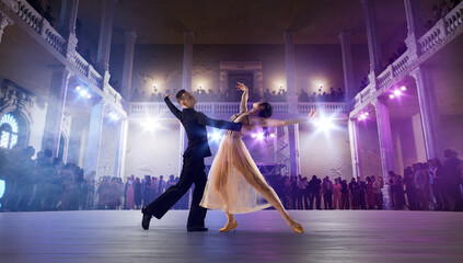 Couple dancers perform waltz on large professional stage. Ballroom dancing.