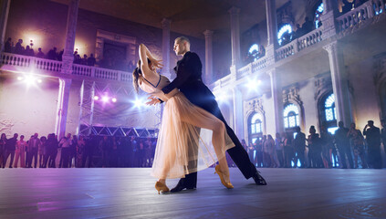 Couple dancers perform waltz on large professional stage. Ballroom dancing.