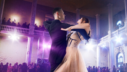Couple dancers perform waltz on large professional stage. Ballroom dancing.