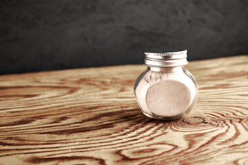 black salt Kala namak finely ground in a glass salt shaker on a wooden table with a copy space