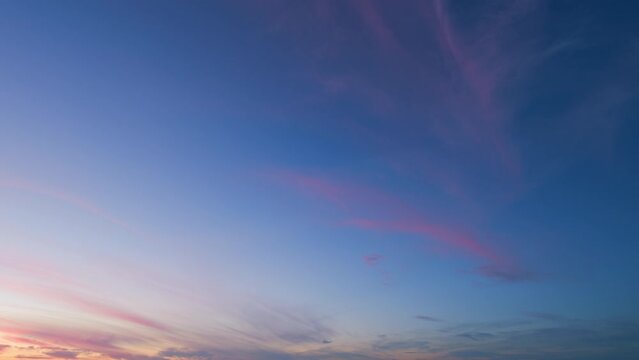 Blue pink purple sunset background. Natural sunset white clouds floating on blue sky. Timelapse.