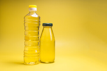 Sunflower oil in transparent bottles close-up on a yellow background copy space