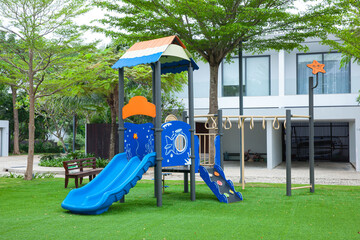 children colorful playground with slides and climbing bars on green grass in the park