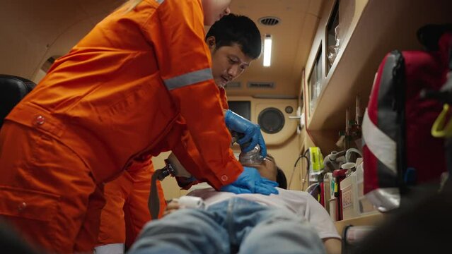 Asian Emergency Medical Technician (EMT) Or Paramedic Team Heart Pumping CPR The Patient, Sudden Cardiac Arrest Or Cardiopulmonary Resuscitation Concept