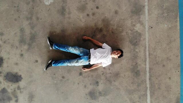Top view of Asian man lying on floor with spinal injury and unable to move, Emergency signs and symptoms of a spinal cord injury after an accident or paralysis concept