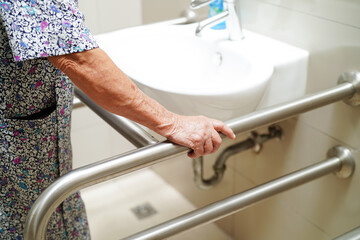 Asian elderly old woman patient use toilet support rail in bathroom, handrail safety grab bar,...