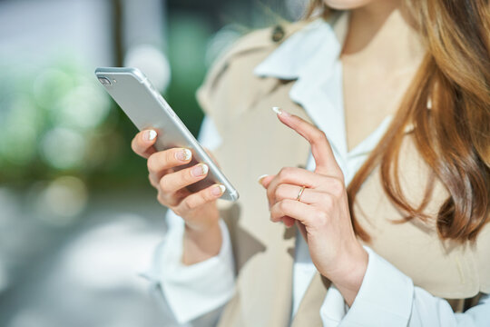 スマートフォンを操作する女性の手元