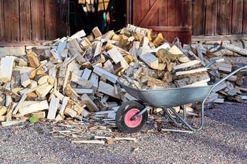 pile of firewood infront of red barn